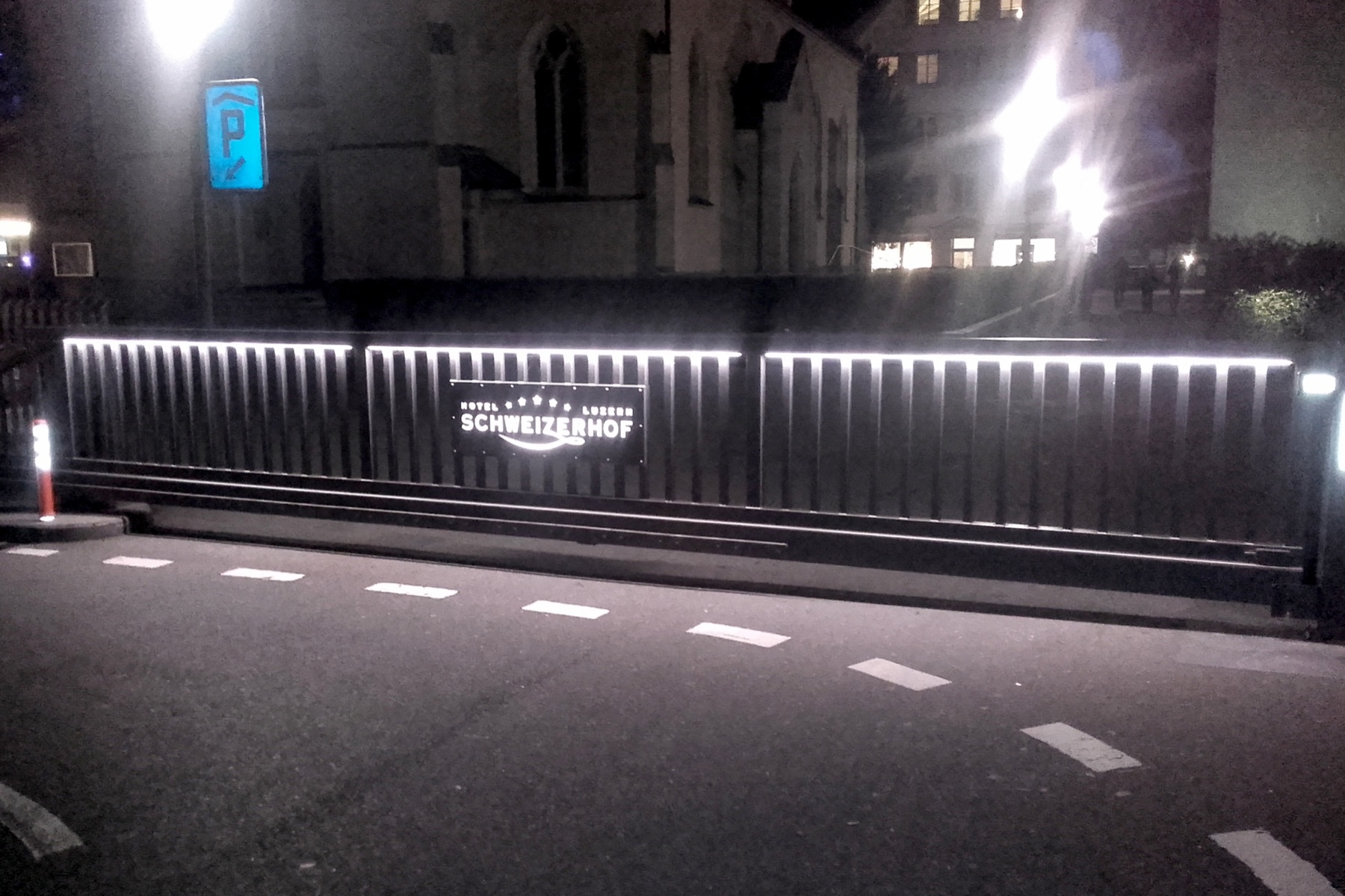 Beleuchtetes Schiebetor aus Aluminium bei Nacht